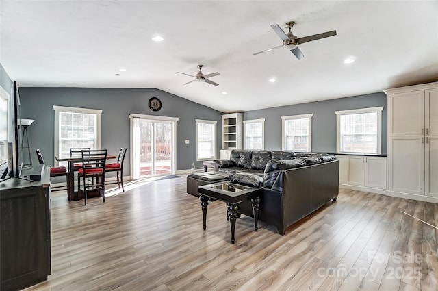 living room featuring light wood-type flooring, ceiling fan, and vaulted ceiling