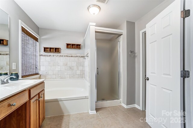 bathroom featuring tile patterned flooring, shower with separate bathtub, and vanity