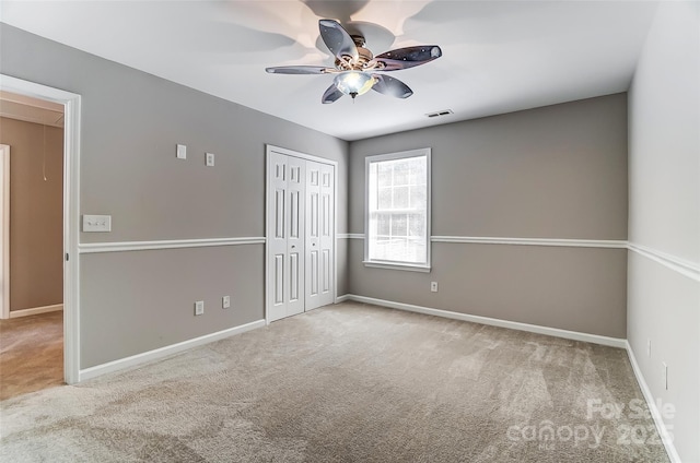 spare room featuring ceiling fan and carpet