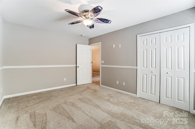 unfurnished bedroom with light carpet, ceiling fan, and a closet