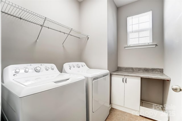 laundry area with light tile patterned floors and washing machine and clothes dryer