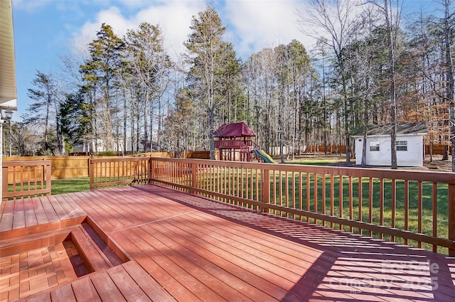 deck featuring an outbuilding, a yard, and a playground