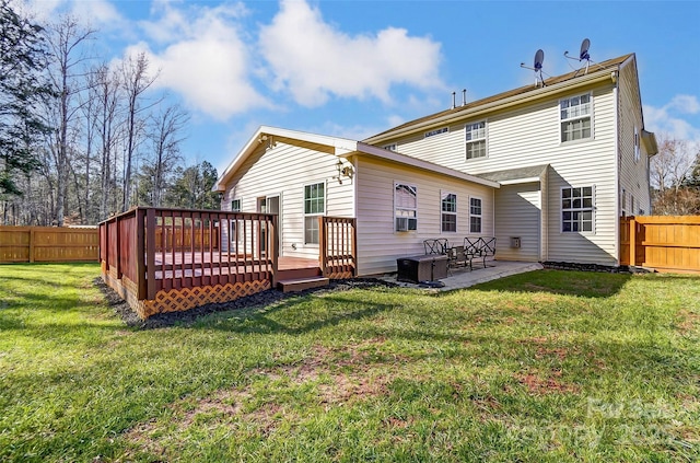 rear view of property featuring a wooden deck, a patio area, and a yard