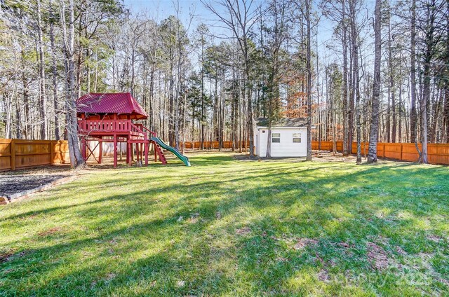 view of yard featuring a storage unit and a playground