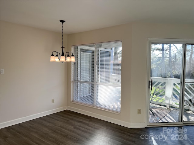 unfurnished dining area with dark hardwood / wood-style flooring and a notable chandelier