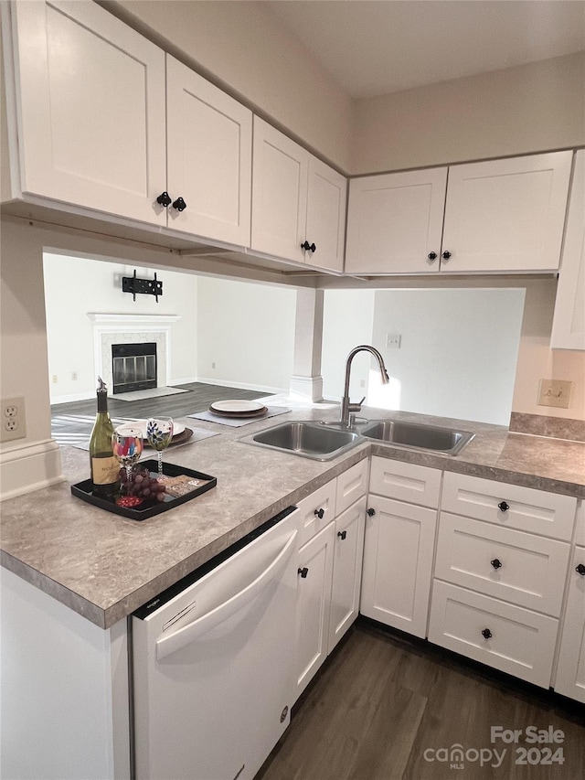 kitchen featuring white dishwasher, dark hardwood / wood-style flooring, white cabinets, and sink