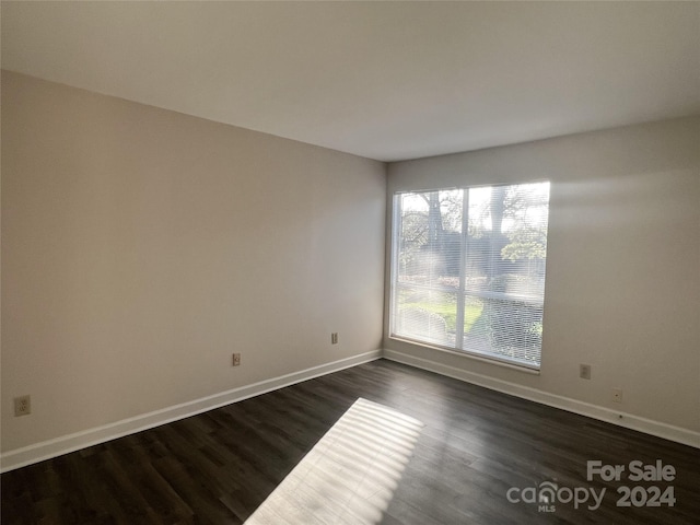 unfurnished room with dark hardwood / wood-style flooring