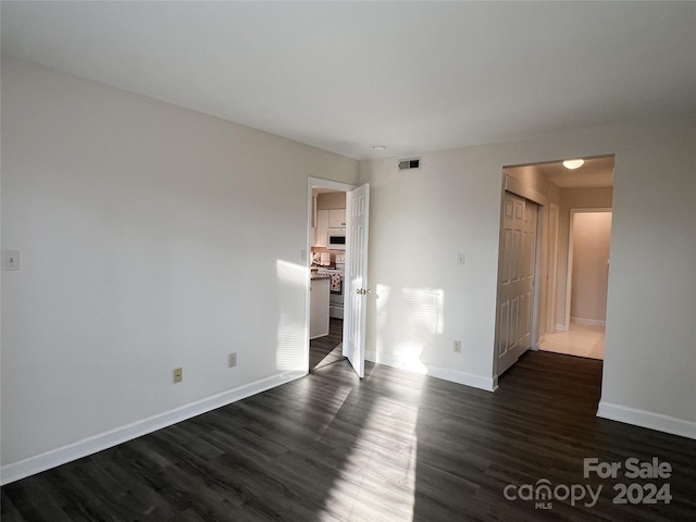 spare room featuring dark wood-type flooring