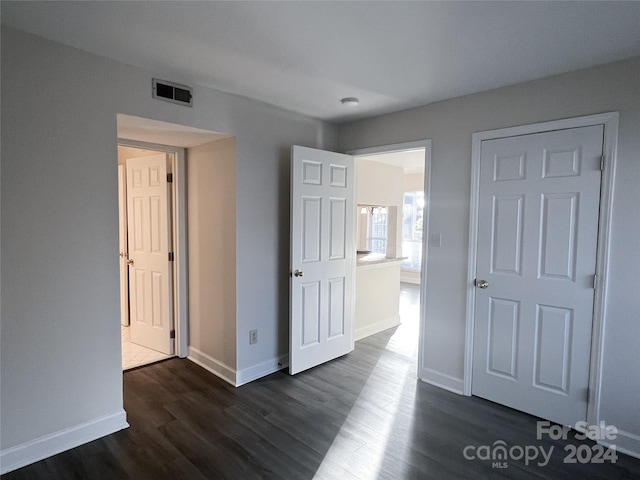 unfurnished bedroom featuring dark hardwood / wood-style flooring