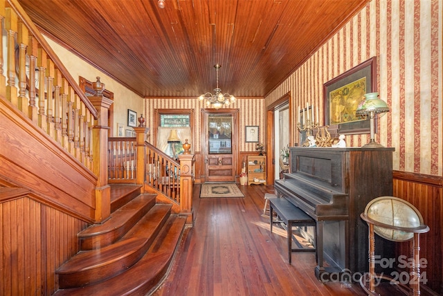 miscellaneous room featuring wooden walls, dark hardwood / wood-style floors, a notable chandelier, and wood ceiling