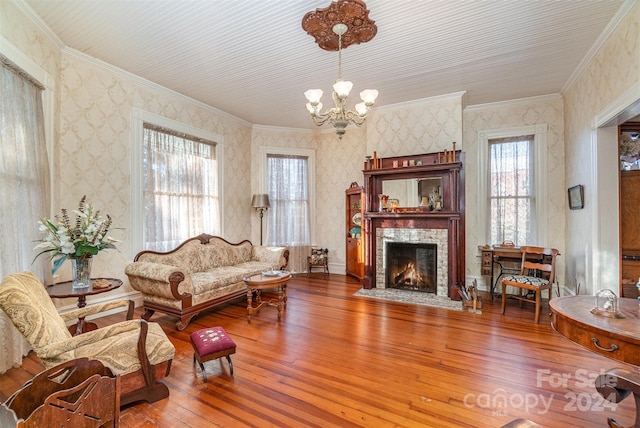 living room with hardwood / wood-style flooring, an inviting chandelier, and crown molding