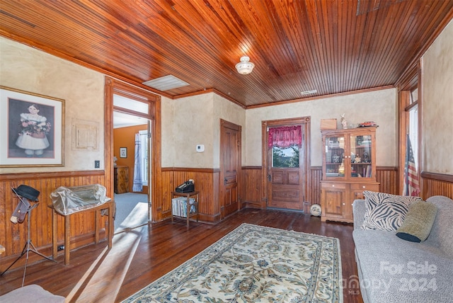 foyer entrance with dark hardwood / wood-style flooring, a wealth of natural light, ornamental molding, wood ceiling, and wooden walls