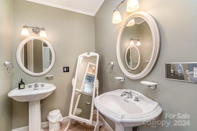 bathroom featuring dual sinks and ornamental molding