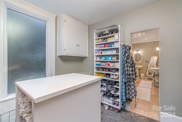 walk in closet with light tile patterned floors