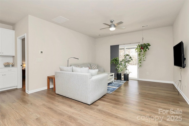 living room featuring ceiling fan and light hardwood / wood-style flooring