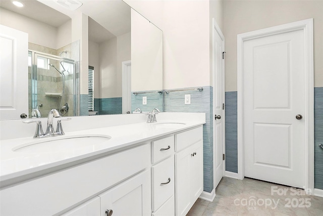 bathroom with vanity, a shower with door, tile patterned flooring, and tile walls