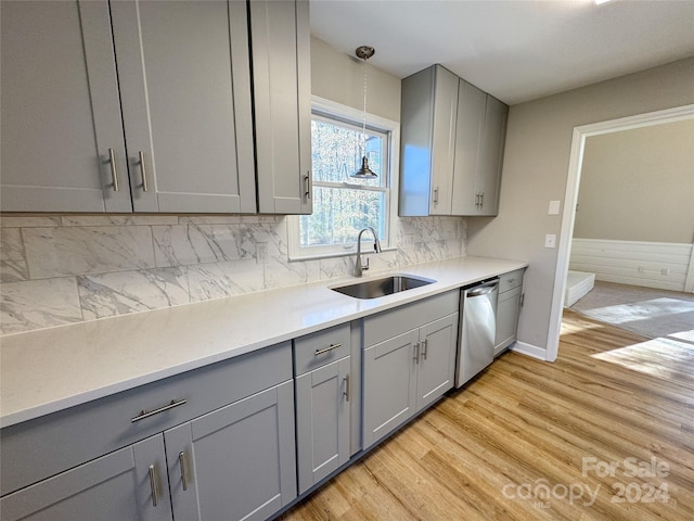 kitchen with light wood-type flooring, gray cabinetry, sink, decorative light fixtures, and dishwasher