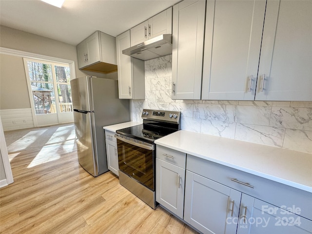 kitchen featuring tasteful backsplash, light wood-type flooring, and appliances with stainless steel finishes