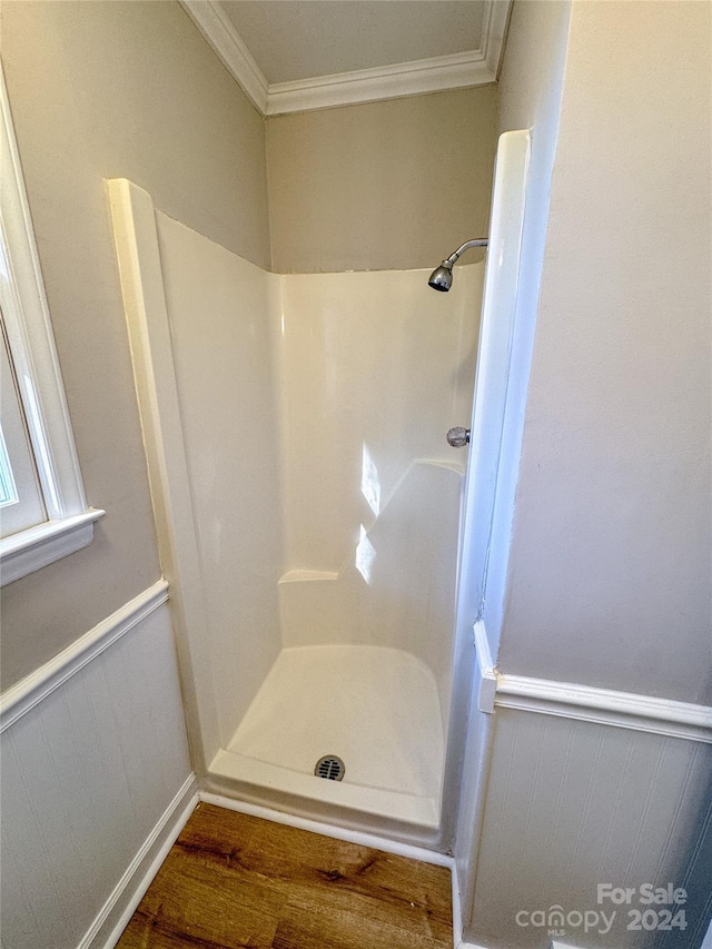 bathroom featuring crown molding, hardwood / wood-style floors, and walk in shower