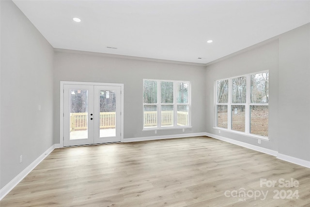 interior space featuring crown molding, french doors, and light wood-type flooring