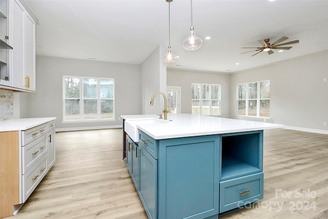 kitchen with pendant lighting, light wood-type flooring, and white cabinetry