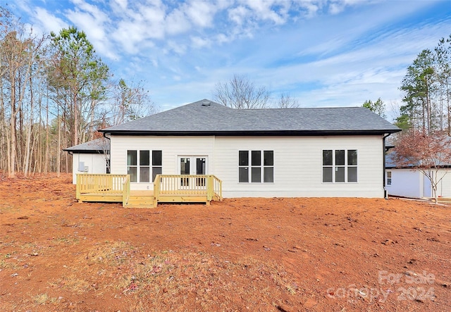 rear view of property with a deck and french doors