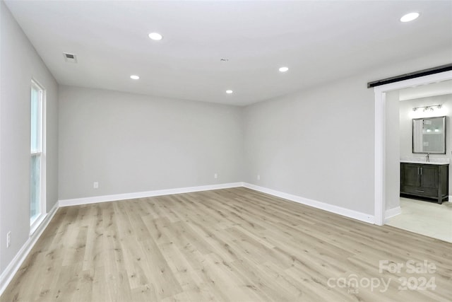 empty room with light hardwood / wood-style flooring and sink