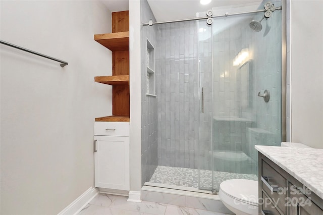 bathroom featuring vanity, a shower with shower door, and toilet