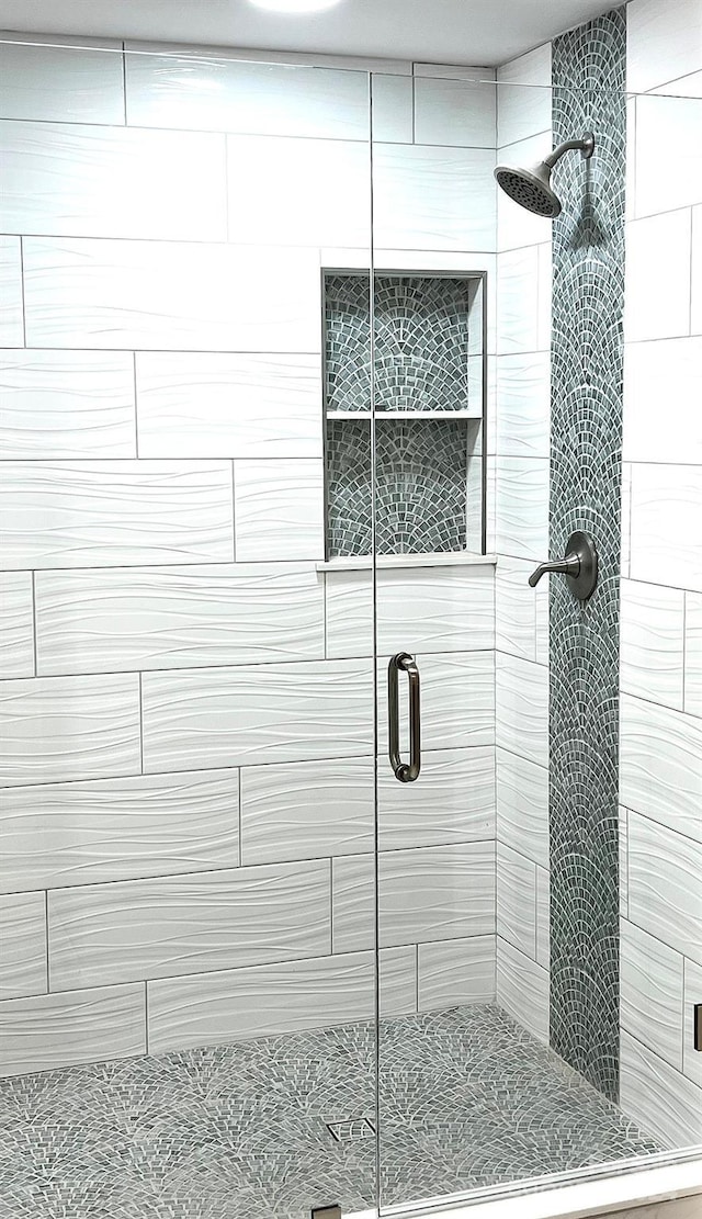 bathroom featuring a shower with shower door