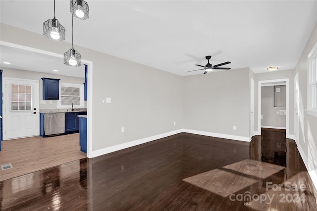 unfurnished living room featuring ceiling fan, dark hardwood / wood-style flooring, and sink