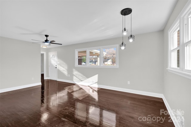 unfurnished living room featuring ceiling fan and dark wood-type flooring