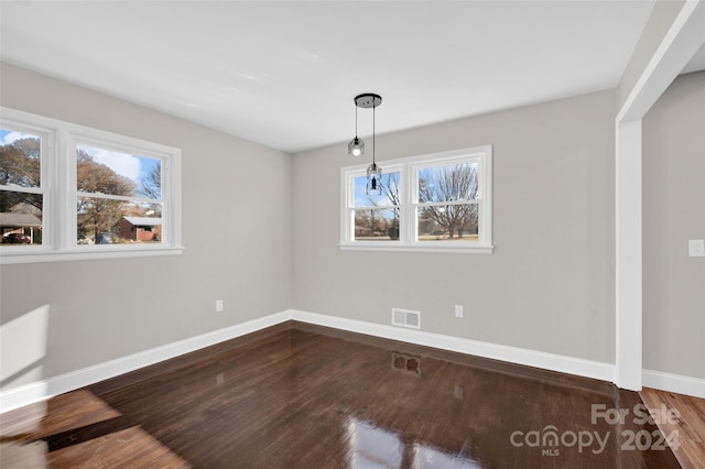 unfurnished dining area with hardwood / wood-style floors and plenty of natural light