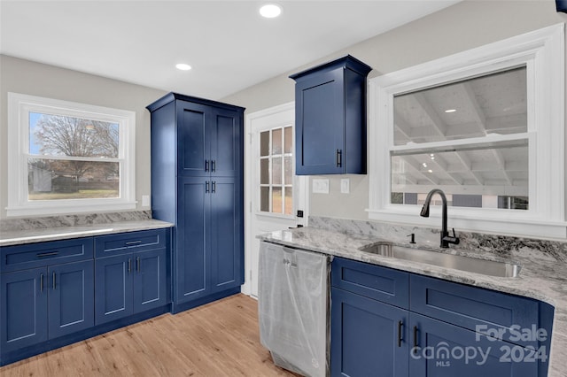 kitchen featuring blue cabinetry, beam ceiling, dishwasher, sink, and light hardwood / wood-style flooring