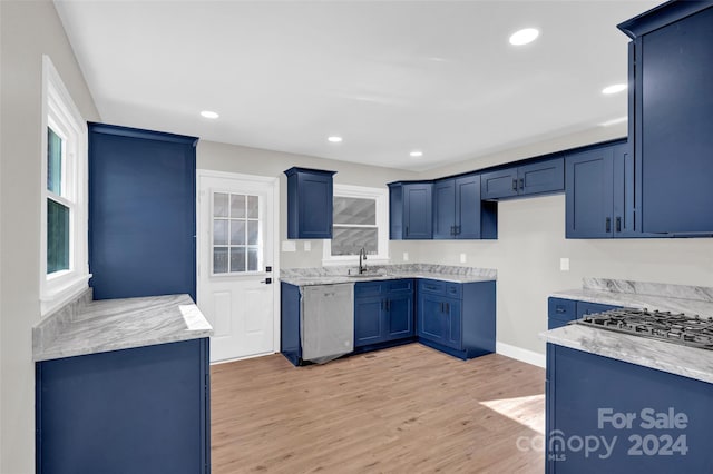 kitchen featuring blue cabinetry, light hardwood / wood-style floors, stainless steel dishwasher, and sink