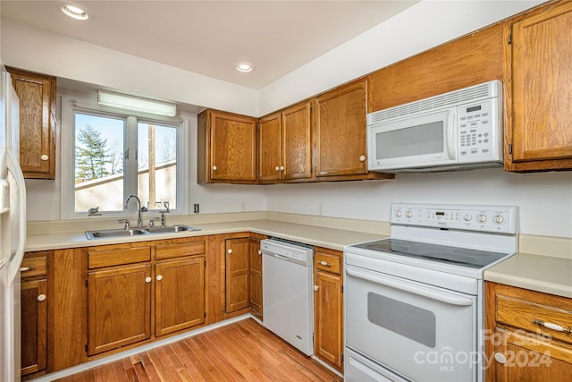 kitchen featuring sink, white appliances, and light wood-type flooring