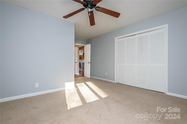 unfurnished bedroom with ceiling fan, light colored carpet, and a closet