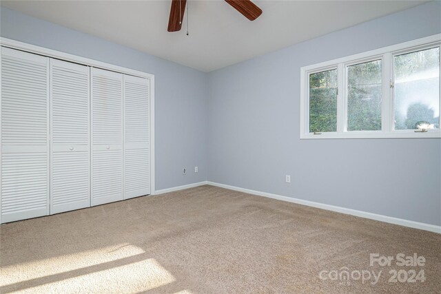 unfurnished bedroom with carpet flooring, a closet, and ceiling fan