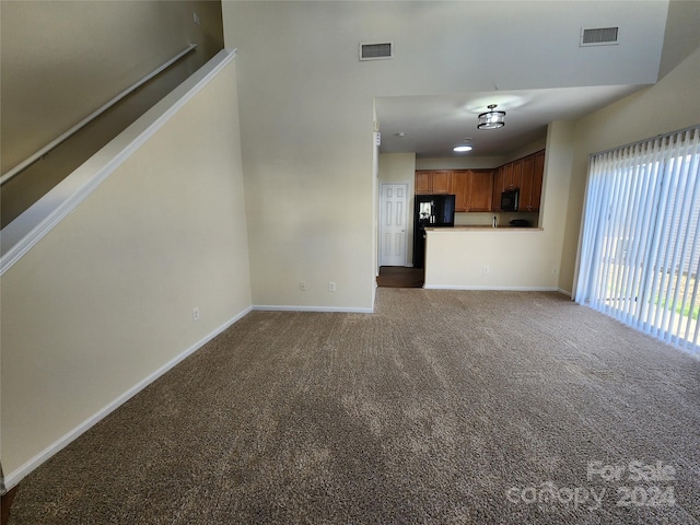 unfurnished living room with dark colored carpet