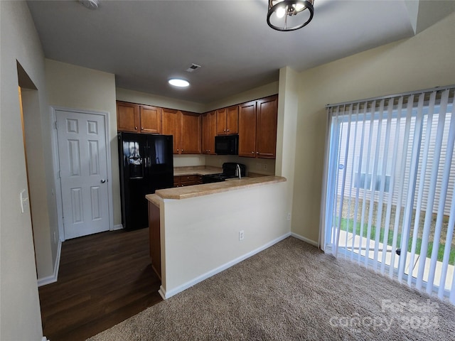 kitchen featuring black appliances, kitchen peninsula, and dark wood-type flooring