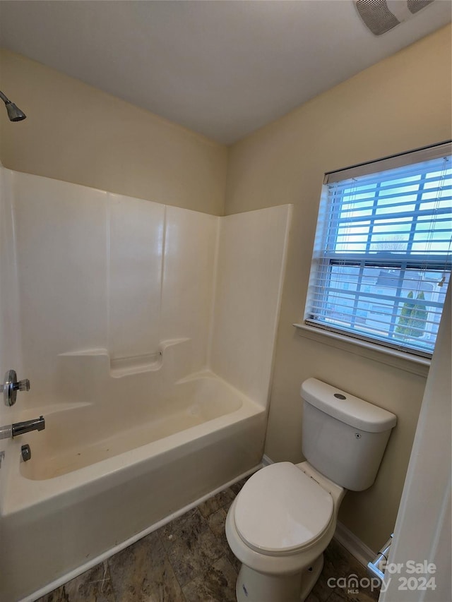 bathroom with shower / bathing tub combination and toilet