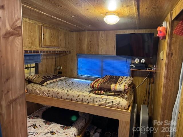 bedroom with wooden ceiling and wooden walls