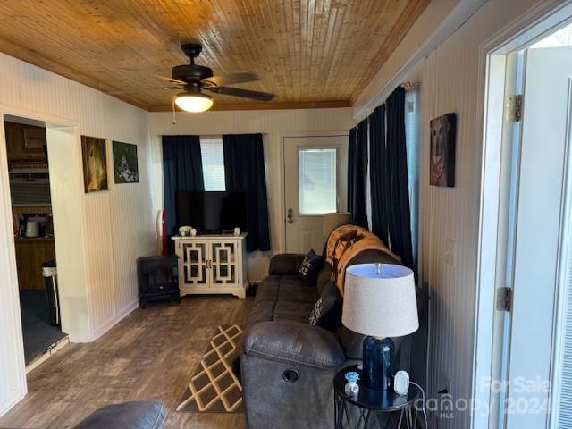 living room with ceiling fan, hardwood / wood-style floors, wood ceiling, and wood walls