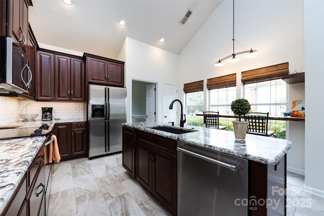 kitchen featuring high vaulted ceiling, light stone countertops, a sink, stainless steel appliances, and backsplash