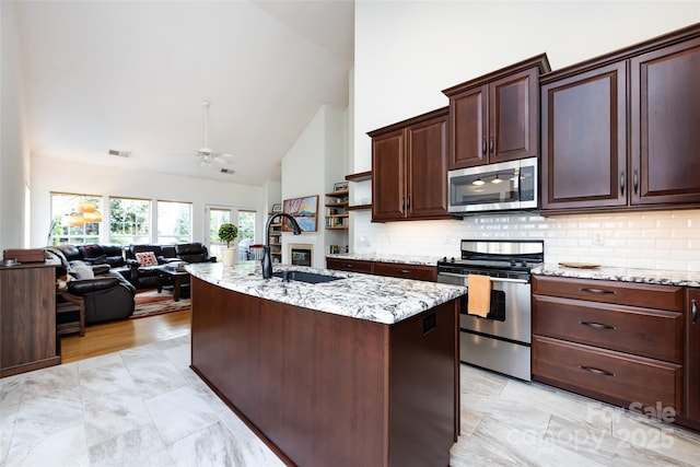 kitchen with visible vents, a sink, a ceiling fan, stainless steel appliances, and high vaulted ceiling