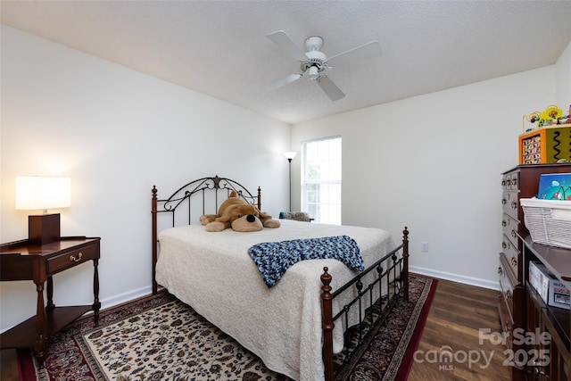 bedroom featuring ceiling fan, baseboards, and wood finished floors