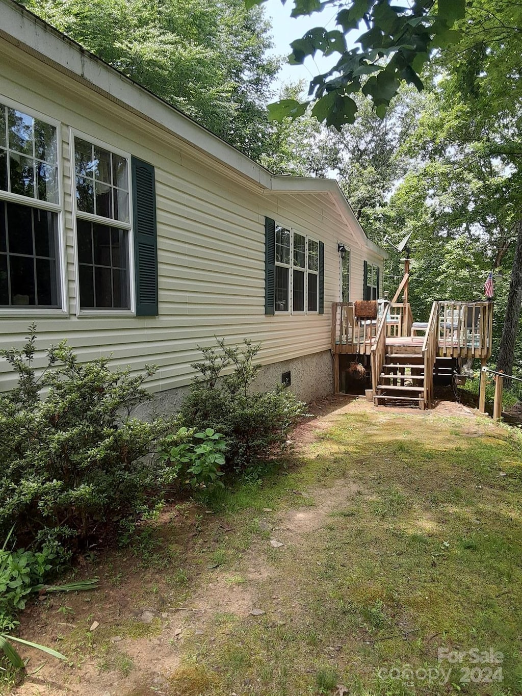 view of property exterior with a deck and a yard