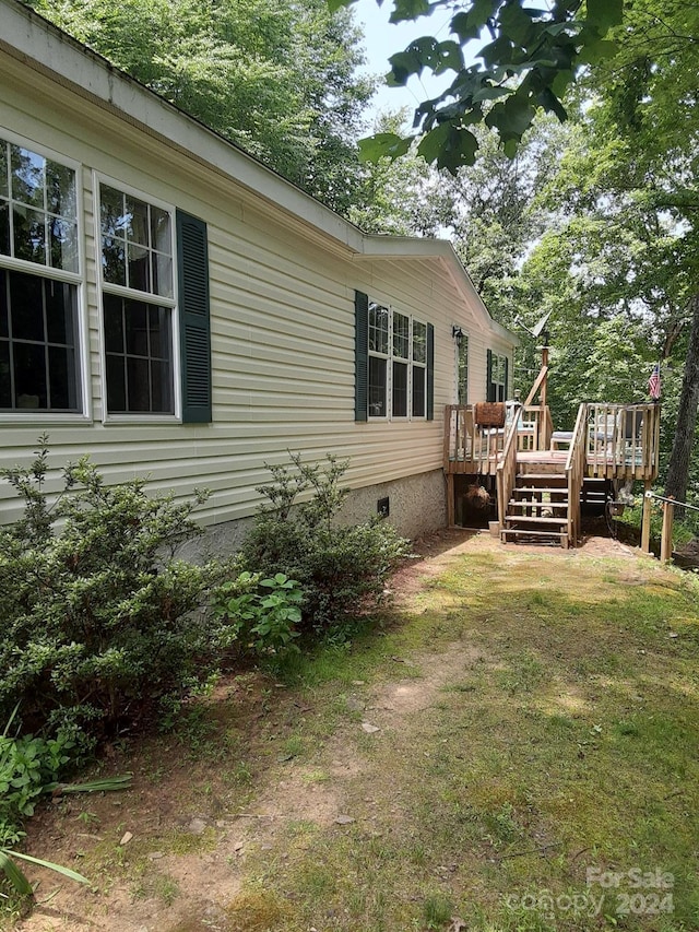 view of property exterior with a deck and a yard