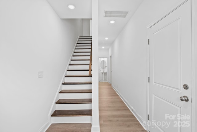 stairs featuring hardwood / wood-style floors