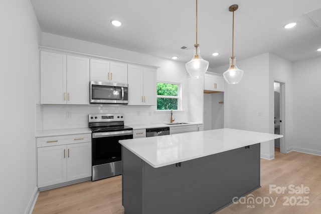 190 Cherry Springs Ln Unit 1-E, Asheville, NC 28804 - kitchen featuring appliances with stainless steel finishes, a sink, decorative backsplash, white cabinets, and light wood-type flooring