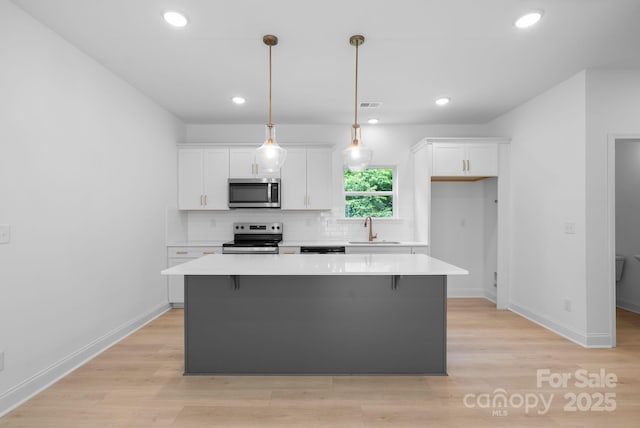 190 Cherry Springs Ln Unit 1-E, Asheville, NC 28804 - kitchen featuring appliances with stainless steel finishes, a sink, white cabinetry, a kitchen island, and recessed lighting